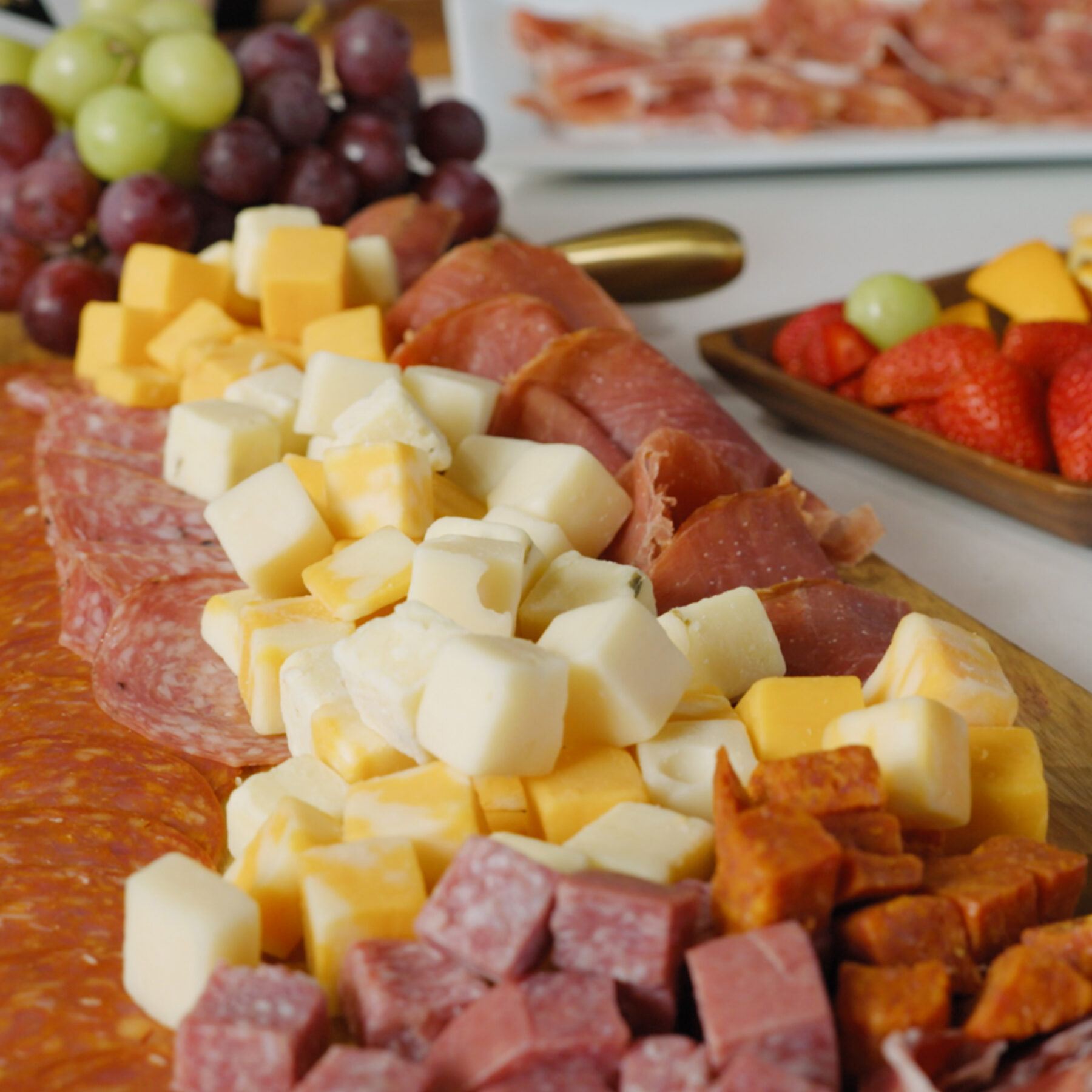 Upper Cut Half Serrano Ham Leg on a plate with Upper Cut meats & cheeses.